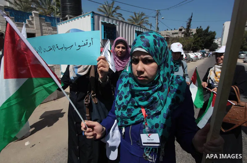 Palestinians hold Palestine flags during a protest against administrative detention of Palestinian prisoners In Israeli jails, in front of the United Nations Development Programme office (UNDP) in Gaza City on April 29,...