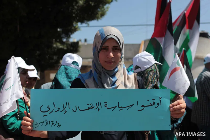 Palestinians hold Palestine flags during a protest against administrative detention of Palestinian prisoners In Israeli jails, in front of the United Nations Development Programme office (UNDP) in Gaza City on April 29,...