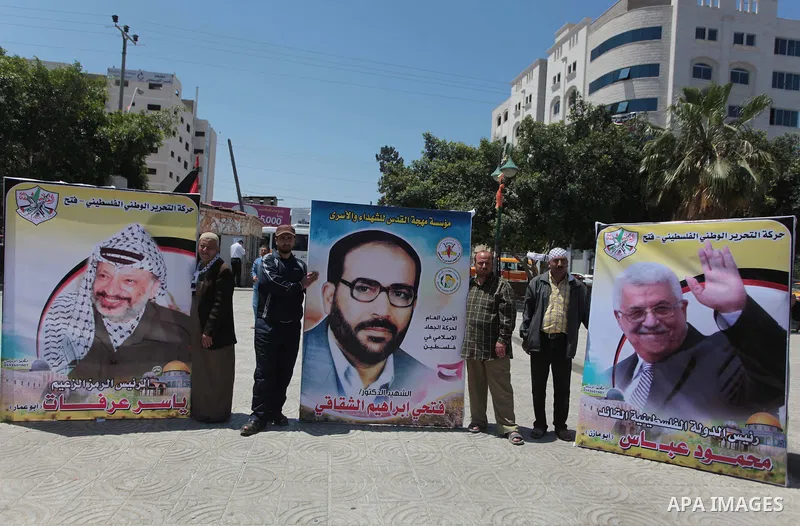 Palestinian families of martyrs who were killed and those that have been wounded in the Israeli-Palestinian conflict in 2008 and 2012, hold placards during a protest against the continued cut of their salaries, in Gaza C...