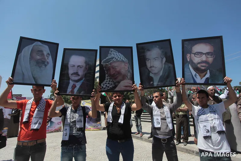 Palestinian families of martyrs who were killed and those that have been wounded in the Israeli-Palestinian conflict in 2008 and 2012, hold placards during a protest against the continued cut of their salaries, in Gaza C...