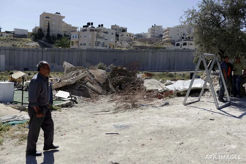 A Palestinian man walks past the remains of his shed after demolished by Israeli bulldozers, in al-Tour neighborhood, east Jerusalem on April 29, 2014. Israeli forces accompanied by bulldozers, stormed Al-Hardub neighbor...