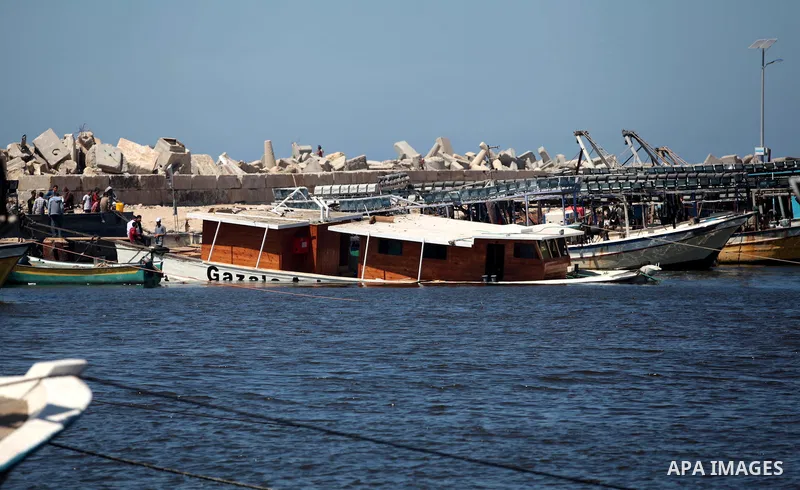 Palestinians inspect the Gaza's Ark, a Palestinian-built protest boat which was preparing to run Israel's naval blockade, after it was damaged in an explosion at the port in Gaza City, on April 29, 2014. The blast occurr...