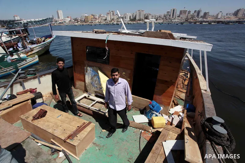 Palestinians inspect the Gaza's Ark, a Palestinian-built protest boat which was preparing to run Israel's naval blockade, after it was damaged in an explosion at the port in Gaza City, on April 29, 2014. The blast occurr...
