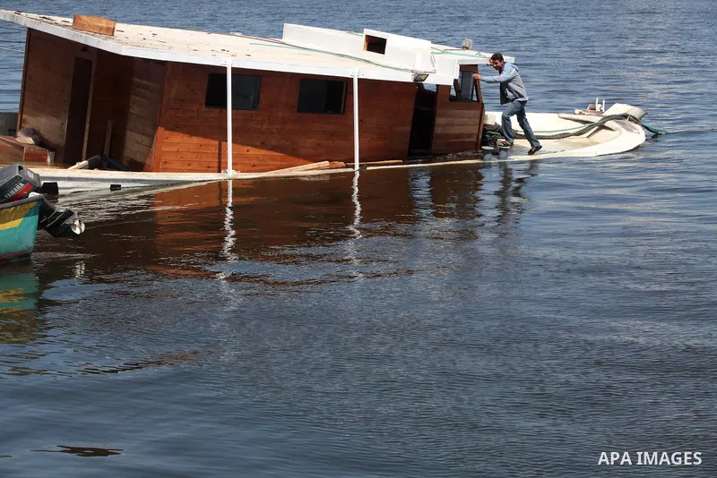 A Palestinian man inspects the Gaza's Ark, a Palestinian-built protest boat which was preparing to run Israel's naval blockade, after it was damaged in an explosion at the port in Gaza City, on April 29, 2014. The blast...
