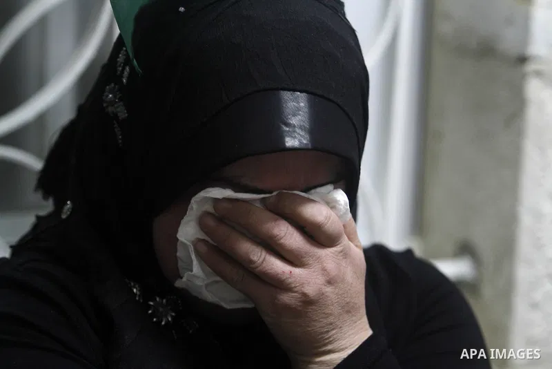 A Palestinian woman reacts as men carry coffins after the remains of four Palestinians were returned from Israel, in the early hours of April 30, 2014 in the West Bank city of Al-Bireh. Israel returned the remains of fou...