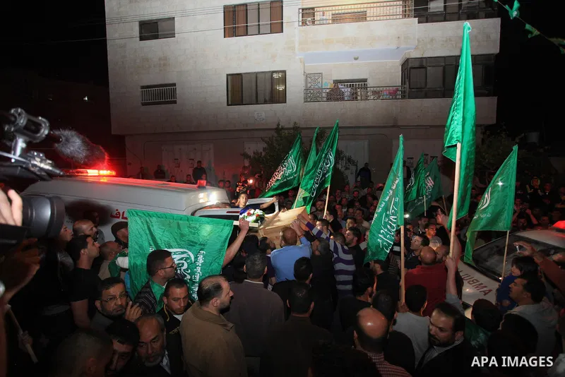 Palestinians carry coffins of two Hamas members Adel and Imad Awadallah, killed in 1998, after their remains were returned from Israel in the early hours of April 30, 2014 in the West Bank city of Al-Bireh. Israel return...