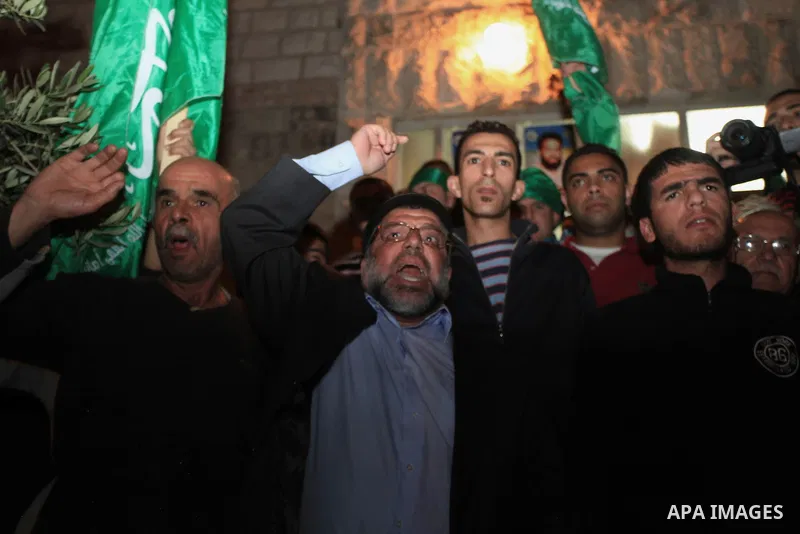 Palestinian protesters shout slogans during the funeral of two Hamas members Adel and Imad Awadallah, killed in 1998, after their remains were returned from Israel in the early hours of April 30, 2014 in the West Bank ci...