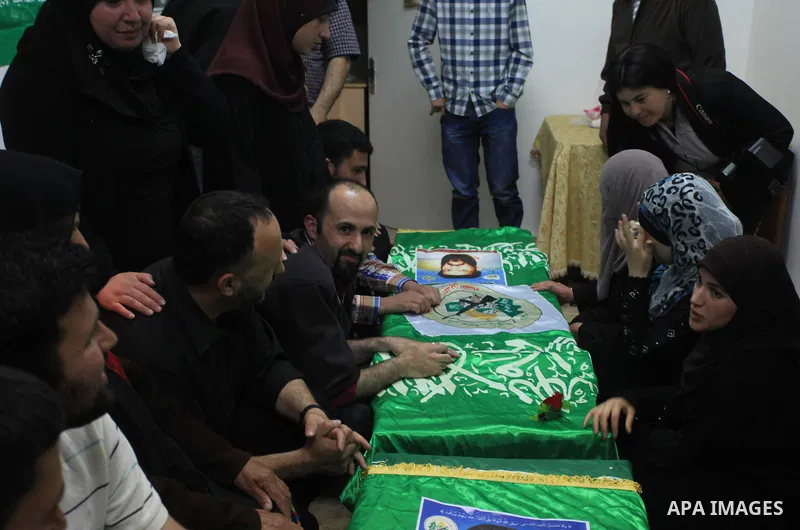 Palestinians gather around of the coffins of two Hamas members Adel and Imad Awadallah, killed in 1998, after their remains were returned from Israel in the early hours of April 30, 2014 in the West Bank city of Al-Bireh...