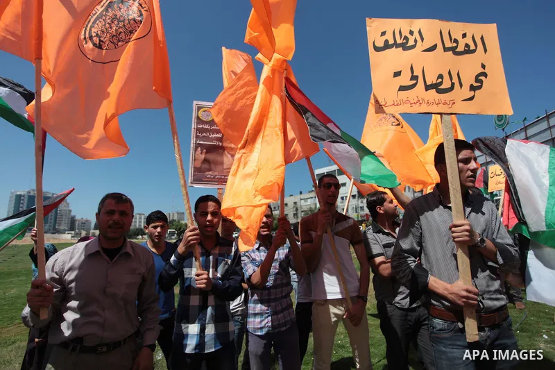Palestinian National Initiative supporters hold placards and national flags during a demonstration to support the national reconciliation in Gaza city, on April 30, 2014. Photo by Ashraf Amra