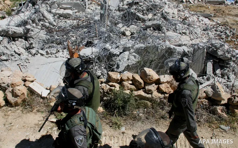 Israeli security forces stand guard as bulldozers demolish a house in Al-Aroub refugee camp, near the West Bank City of Hebron April 30, 2014. Israeli military said that "security forces carried out the demolition of two...