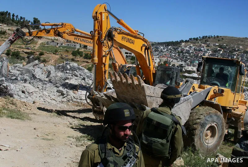 Israeli security forces stand guard as bulldozers demolish a house in Al-Aroub refugee camp, near the West Bank City of Hebron April 30, 2014. Israeli military said that "security forces carried out the demolition of two...
