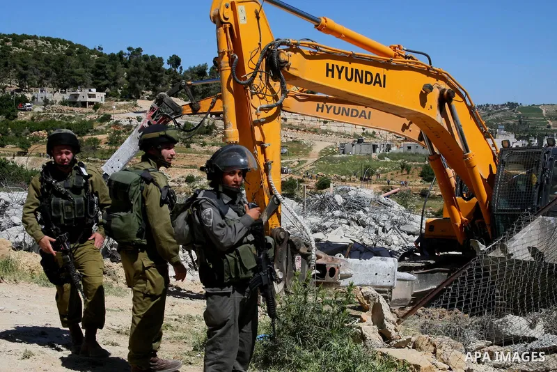 Israeli security forces stand guard as bulldozers demolish a house in Al-Aroub refugee camp, near the West Bank City of Hebron April 30, 2014. Israeli military said that "security forces carried out the demolition of two...