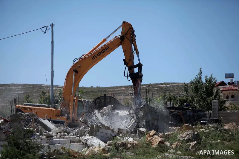 A bulldozer Israeli demolishes a house in Al-Aroub refugee camp, near the West Bank City of Hebron April 30, 2014. Israeli military said that "security forces carried out the demolition of two construction sites that wer...