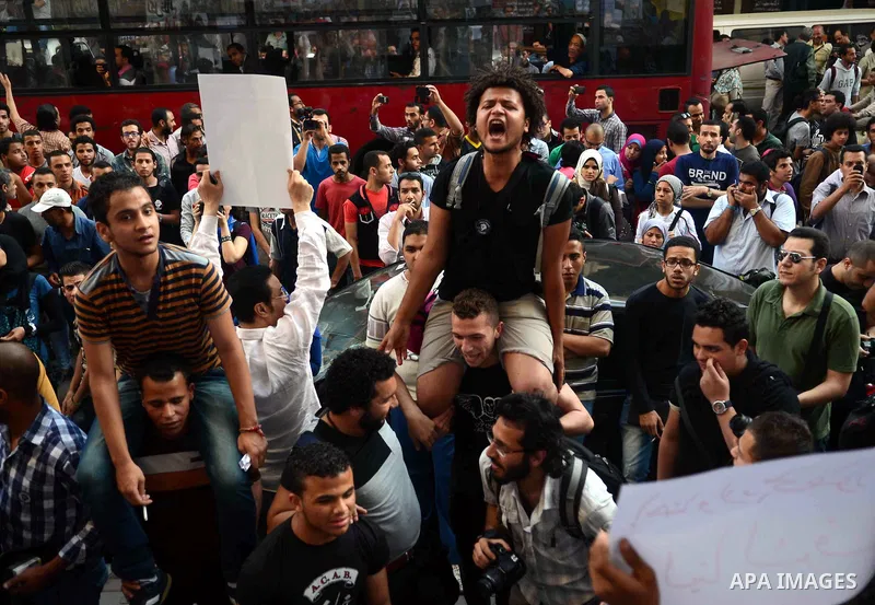 Members of the April 6 movement and liberal activists hold placards and shout slogans during a demonstration outside the Journalists Syndicate, in Cairo on April 30, 2014. The April 6 youth movement has vowed to keep ope...