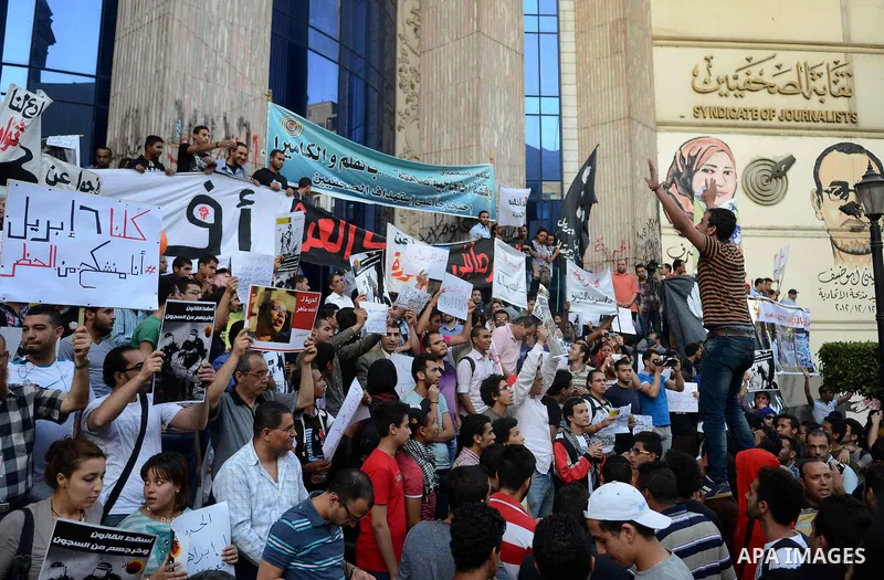 Members of the April 6 movement and liberal activists hold placards and shout slogans during a demonstration outside the Journalists Syndicate, in Cairo on April 30, 2014. The April 6 youth movement has vowed to keep ope...