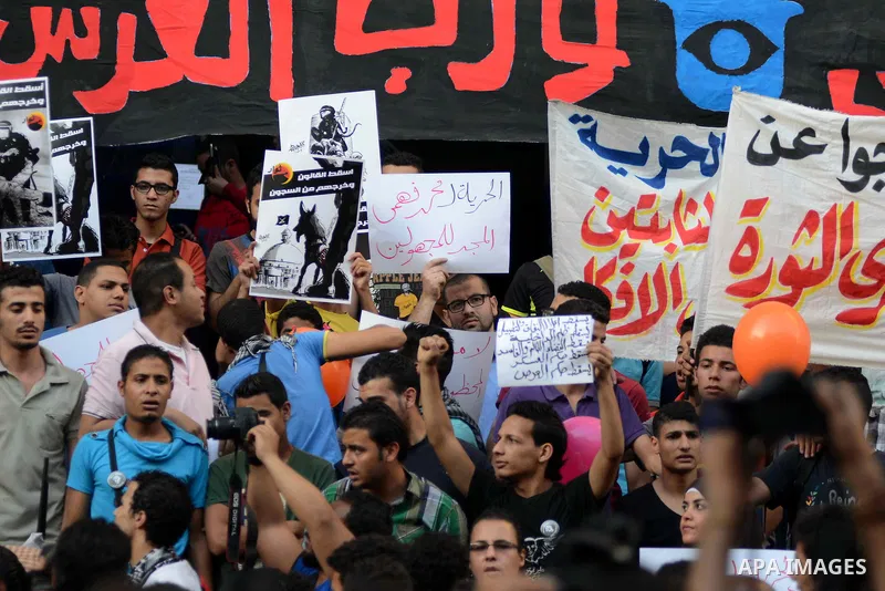 Members of the April 6 movement and liberal activists hold placards and shout slogans during a demonstration outside the Journalists Syndicate, in Cairo on April 30, 2014. The April 6 youth movement has vowed to keep ope...