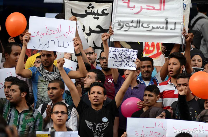 Members of the April 6 movement and liberal activists hold placards and shout slogans during a demonstration outside the Journalists Syndicate, in Cairo on April 30, 2014. The April 6 youth movement has vowed to keep ope...