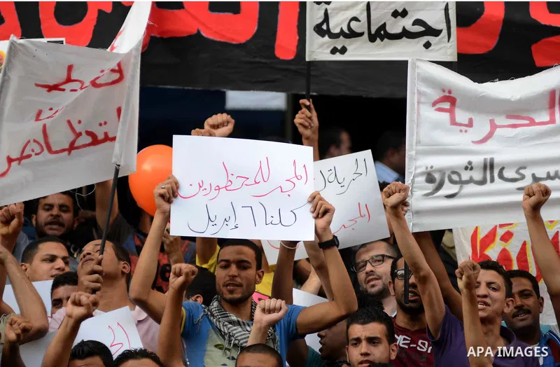 Members of the April 6 movement and liberal activists hold placards and shout slogans during a demonstration outside the Journalists Syndicate, in Cairo on April 30, 2014. The April 6 youth movement has vowed to keep ope...
