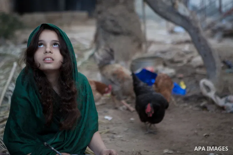 A Palestinian girl plays outside her family's house, in the east of ‎Gaza‬ City near the border with Israel, May 1, 2014. Photo by Ezz Zanoun