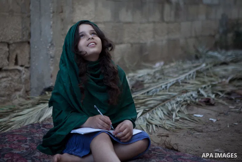 A Palestinian girl plays outside her family's house, in the east of ‎Gaza‬ City near the border with Israel, May 1, 2014. Photo by Ezz Zanoun