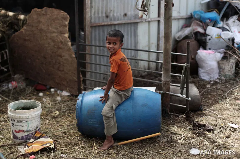 A Palestinian Bedouin boy plays outside a shed near his family's house, in Gaza City on May 04, 2014. Photo by Ashraf Amra