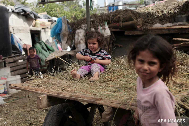 Palestinian Bedouin children play outside a shed near their family's house, in Gaza City on May 04, 2014. Photo by Ashraf Amra