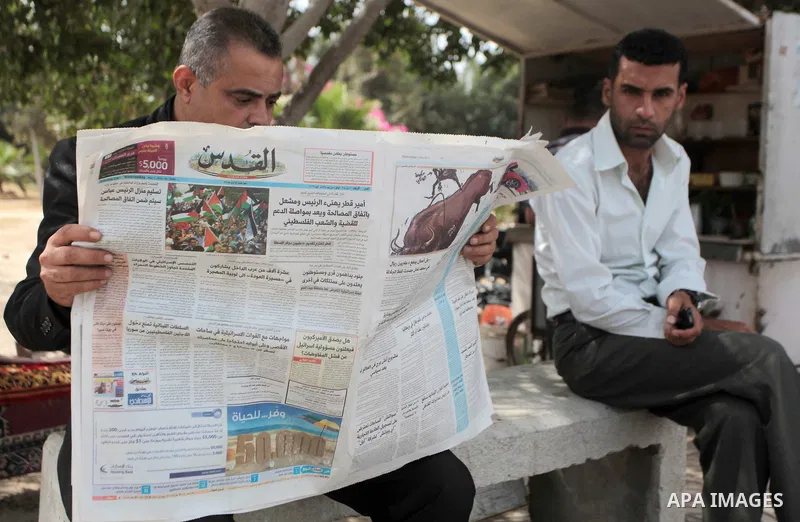 A Palestinian man reads the Al-Quds Newspaper on the first day of its arrival to Gaza from the West bank since being banned by Hamas in 2008, in Gaza City, in the northern Gaza Strip, Wednesday, May 7, 2014. Gaza s Hamas...