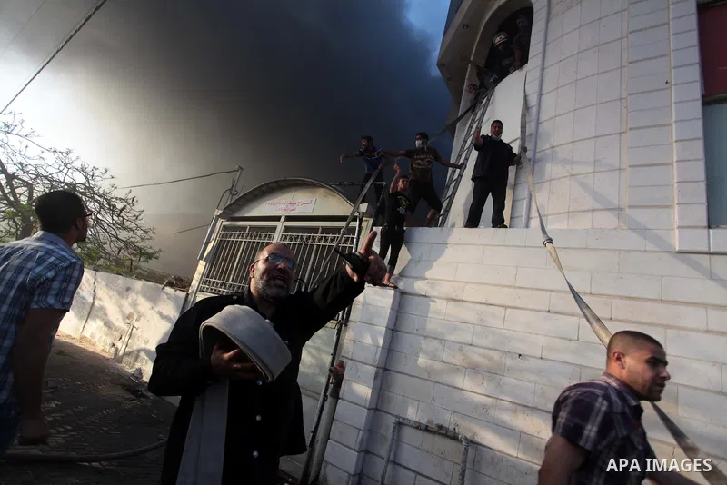 Palestinian firefighters try to extinguish a fire after a fire swept over a store of Electrical appliances in Gaza city on May 10, 2014. Photo by Ashraf Amra