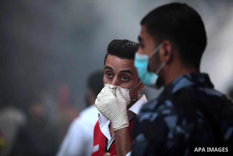 Palestinian policemen help firefighter to extinguish a fire after a fire swept over a store of Electrical appliances in Gaza city on May 10, 2014. Photo by Ashraf Amra