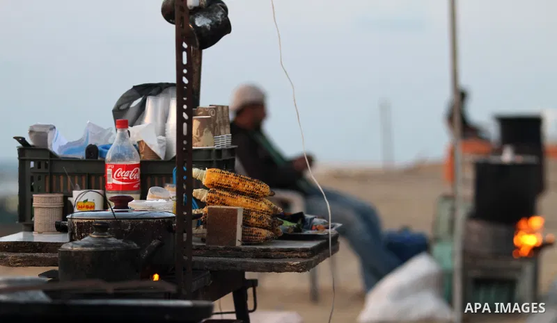 A Palestinian man sells corn on the sea at Gaza beach on May 11, 2014. Photo by Yasser Qudih