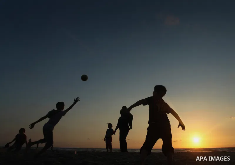 Palestinians enjoy playing during the sunset in the sea at Gaza beach on May 11, 2014. Photo by Yasser Qudih