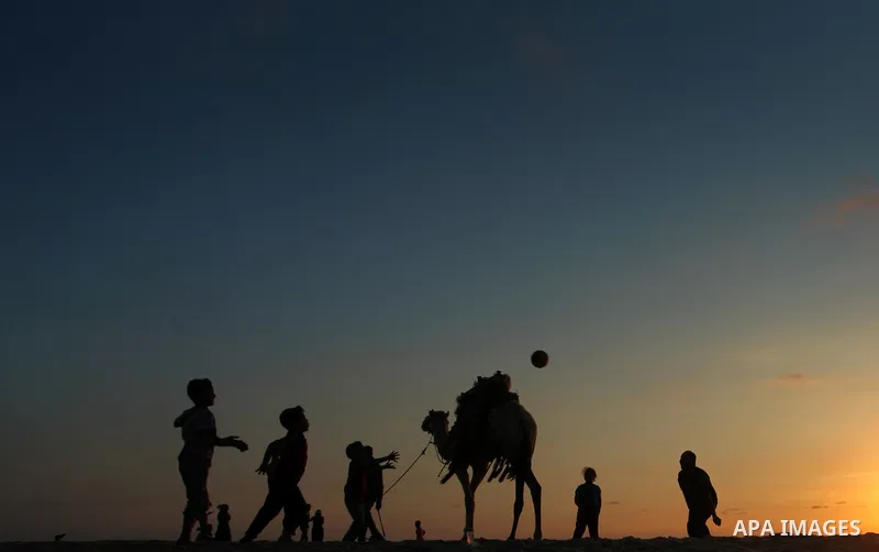 Palestinians enjoy playing during the sunset in the sea at Gaza beach on May 11, 2014. Photo by Yasser Qudih