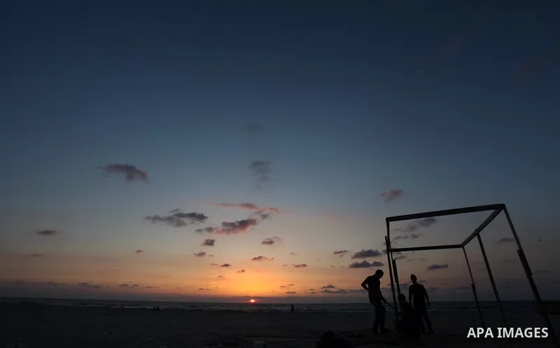 Palestinian youths build a tent in front of the sea at Gaza beach on May 11, 2014. Photo by Yasser Qudih
