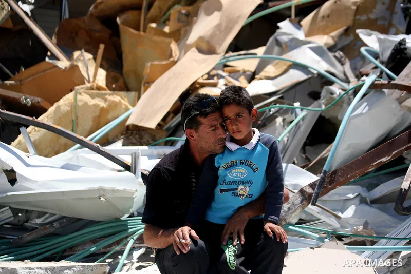 A Palestinian man with his son set on the rubbles of his house after demolish by Israeli municipality bulldozers under the pretext of building without permit, at Jabal al-Mukaber district, East Jerusalem May 14, 2014. Is...
