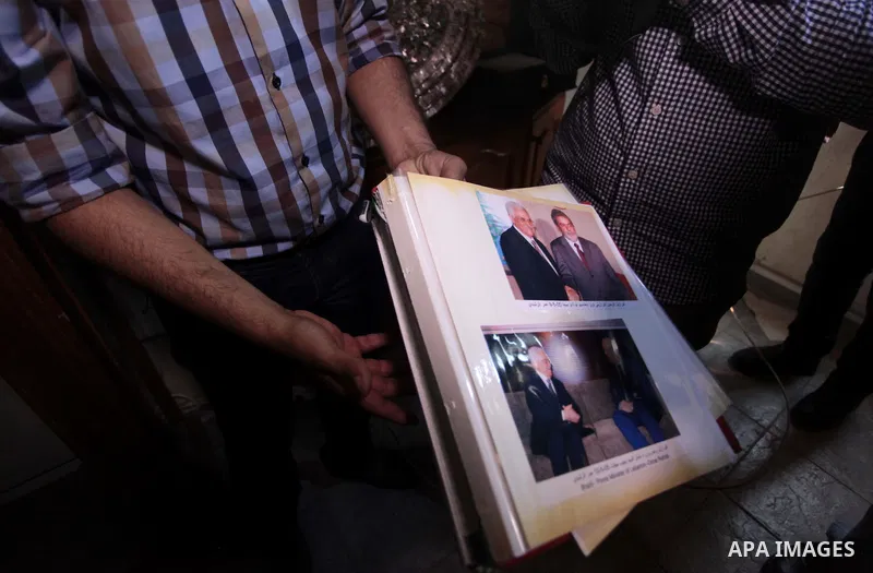 A member of the Palestinian security forces loyal to Hamas shows pictures of Palestinia president Mahmoud Abbas at Abbas's house in Gaza City May 14, 2014, as they prepare to handover the house which Hamas seized during...
