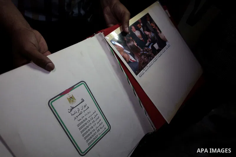 A member of the Palestinian security forces loyal to Hamas shows pictures of Palestinia president Mahmoud Abbas at Abbas's house in Gaza City May 14, 2014, as they prepare to handover the house which Hamas seized during...