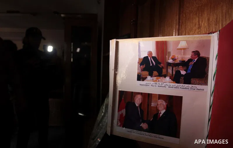 A member of the Palestinian security forces loyal to Hamas shows pictures of Palestinia president Mahmoud Abbas at Abbas's house in Gaza City May 14, 2014, as they prepare to handover the house which Hamas seized during...