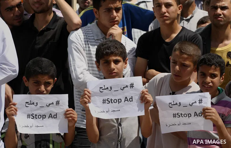 Palestinians hold banners during a demonstrator calling for the end of administrative detention as others wave their national flag in Gaza City on May 16, 2014 after Friday prayers to express solidarity with Palestinian...
