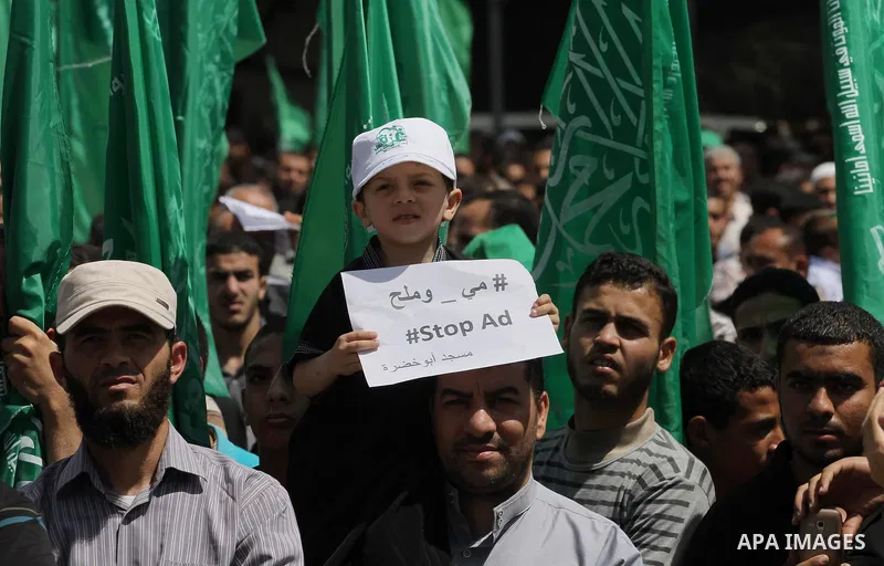 Palestinians hold banners during a demonstrator calling for the end of administrative detention as others wave their national flag in Gaza City on May 16, 2014 after Friday prayers to express solidarity with Palestinian...
