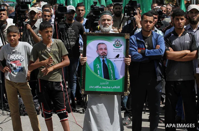 Palestinians hold banners during a demonstrator calling for the end of administrative detention as others wave their national flag in Gaza City on May 16, 2014 after Friday prayers to express solidarity with Palestinian...