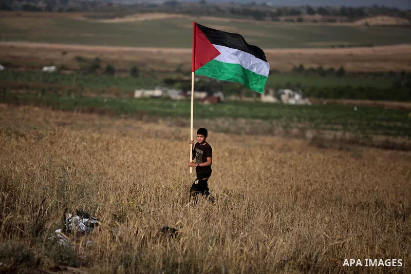 A Palestinian child waves his national flag to mark the Nakba or the ''Day of Catastrophe'' in Beit Hanoun in the northern Gaza Strip, on May 17, 2014.Palestinians marked ''Nakba'' to commemorate the expulsion or fleeing...
