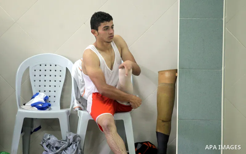 Palestinian Motasim Abu Karsh, 17, rests after swimming in a pool at a club in Gaza City May 18, 2014. Abu Karsh lost his leg after he was injured during an Israeli air strike in 2005. He won the first place in the frees...