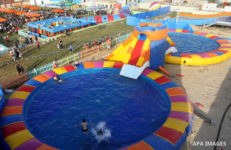 Palestinian children play in a pool at Aqua Park, in Gaza City May 22, 2014. Photo by Mohammed Asad