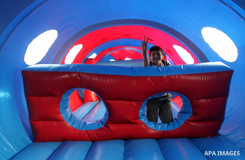 A Palestinian boy flashes victory sign as he plays on a huge water slide at Aqua Park, in Gaza City May 22, 2014. Photo by Mohammed Asad