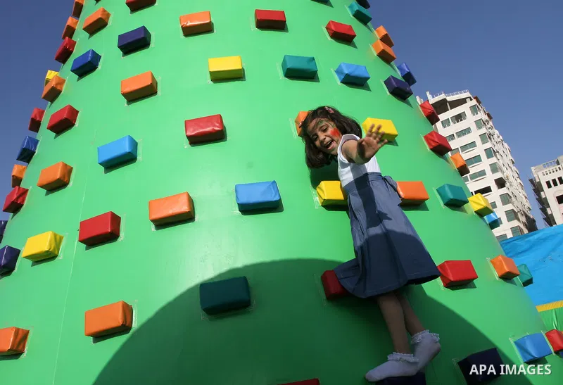 A Palestinian girl plays on a huge inflatable toy at Aqua Park, in Gaza City May 22, 2014. Photo by Mohammed Asad