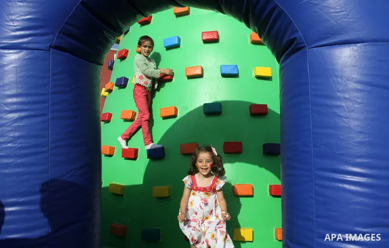 Palestinian girls play on a huge inflatable toy at Aqua Park, in Gaza City May 22, 2014. Photo by Mohammed Asad