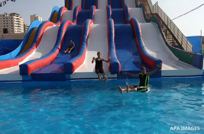 Palestinian children slide down a huge water slide at Aqua Park, in Gaza City May 22, 2014. Photo by Mohammed Asad
