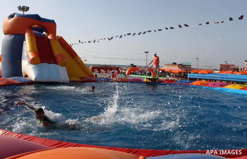 Palestinian children play in a pool at Aqua Park, in Gaza City May 22, 2014. Photo by Mohammed Asad