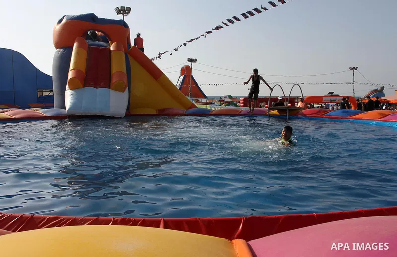 Palestinian children play in a pool at Aqua Park, in Gaza City May 22, 2014. Photo by Mohammed Asad
