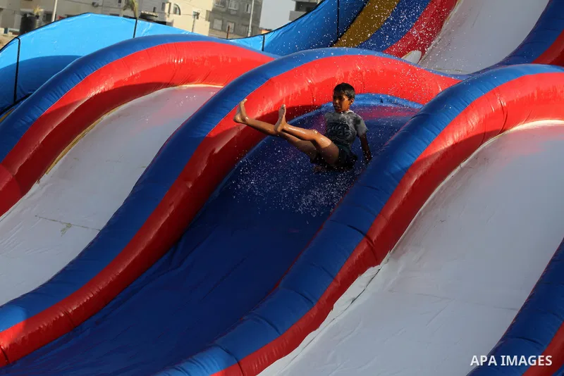 A Palestinian boy slides down a huge water slide at Aqua Park, in Gaza City May 22, 2014. Photo by Mohammed Asad